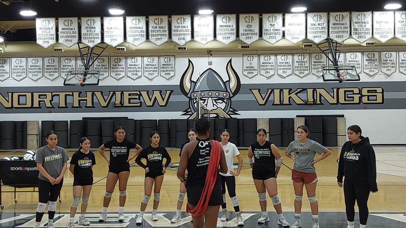 Coach Peters addressing the Northview High School girls volleyball team on their home court.