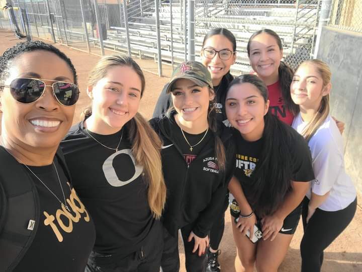 Coach Peters and young Latina athletes at a leadership event.