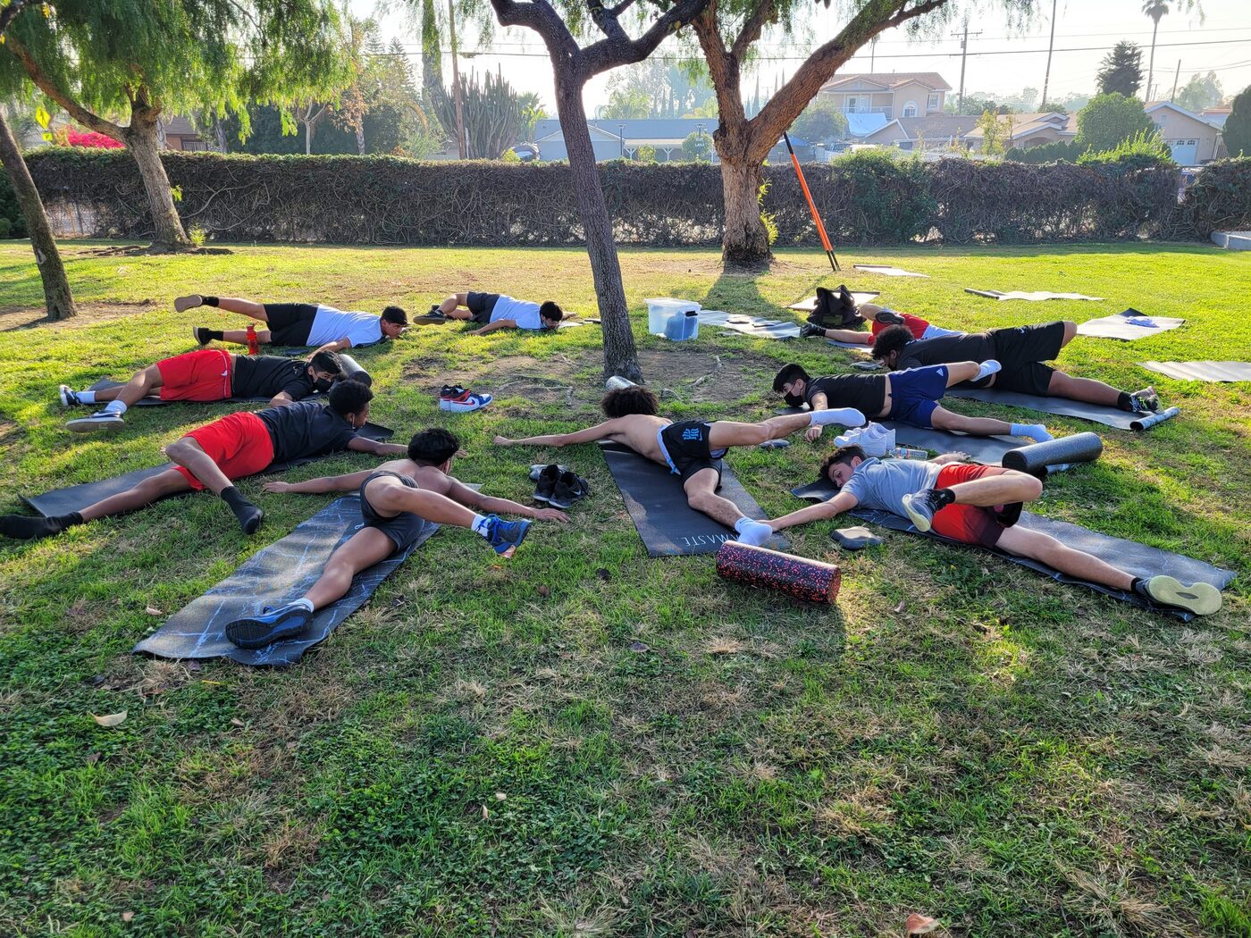 A team working through a guided mobility and recovery session on the grass.