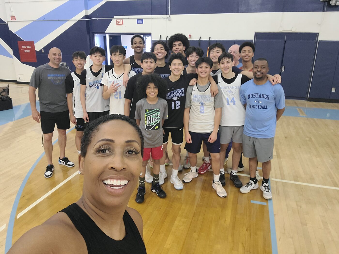 Coach Peters with the Walnut High School boys basketball team on their home court.