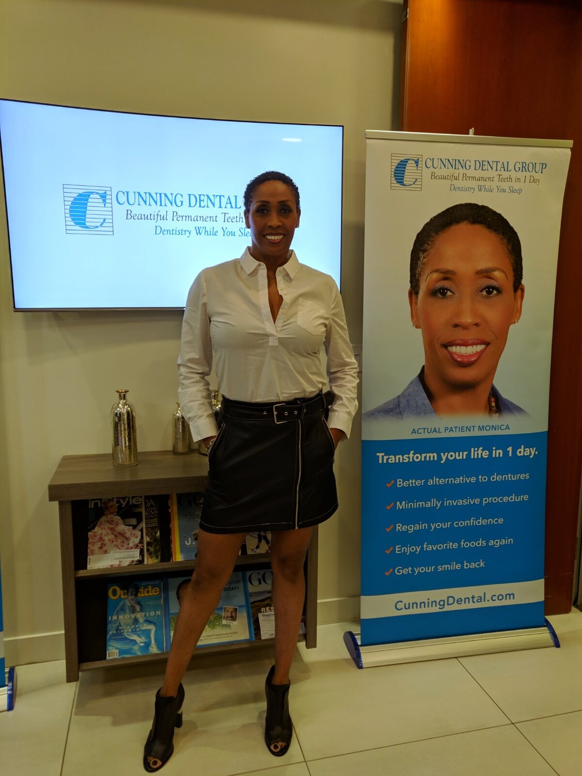 Coach Peters standing beside her Cunning Dental Group 'Actual Patient' banner.